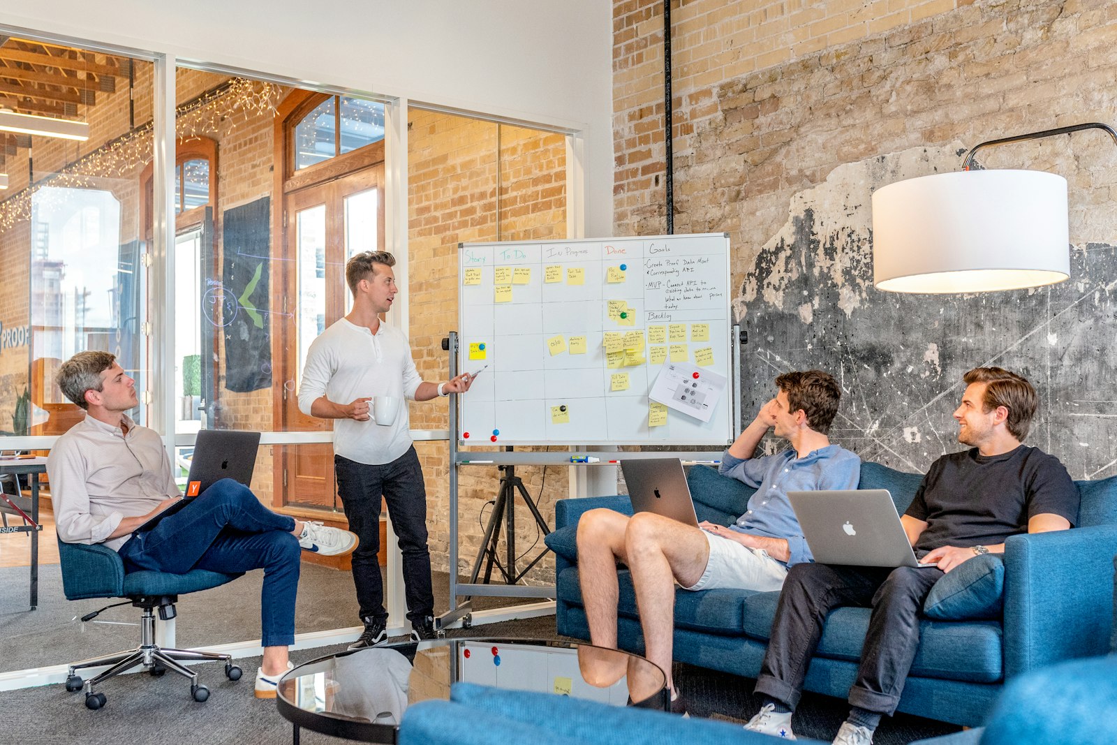 Small team gathered around a whiteboard in a casual meeting space
